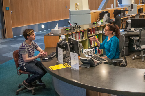 service desk showing a librarian speaking with a student